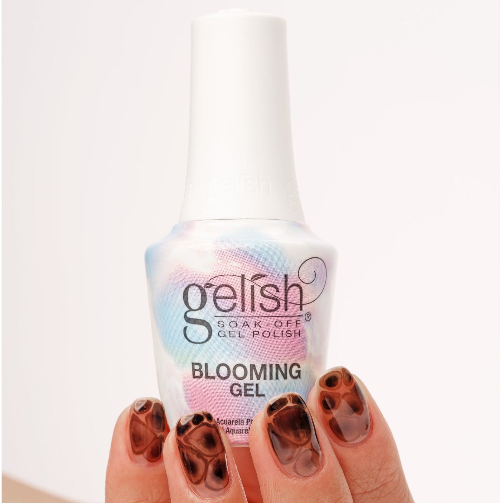 Gelish soaking gel polish bottle with a hand displaying nails painted with a similar design.