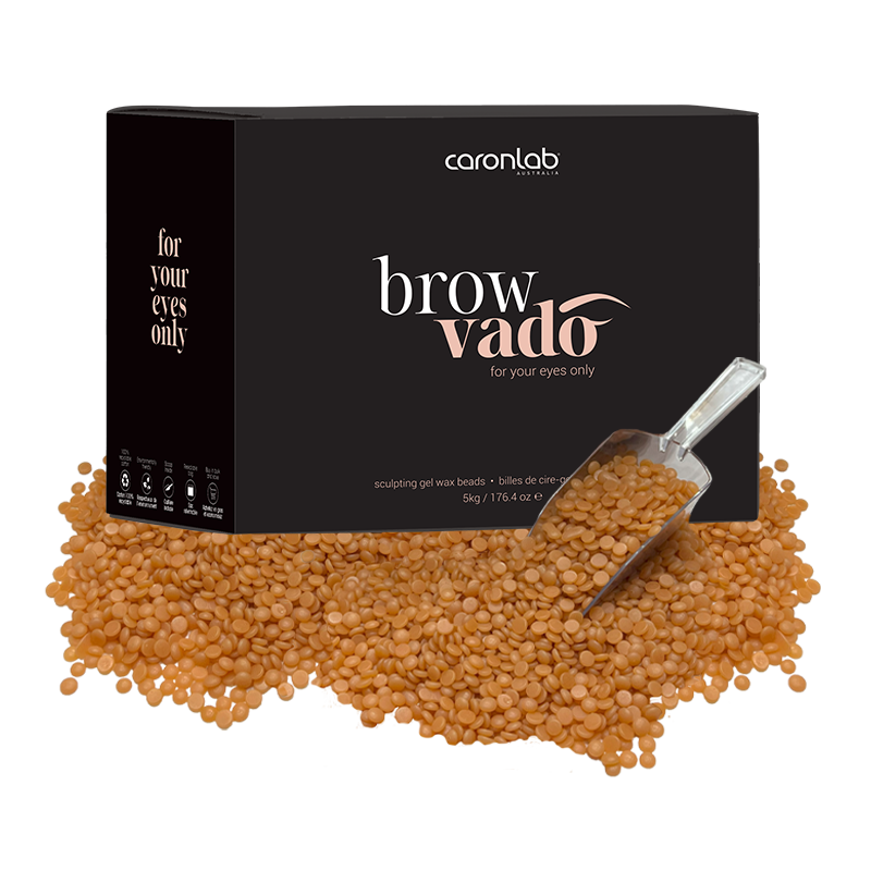 Caronlab brow vado packaging with brown wax beads and a scoop on a white background