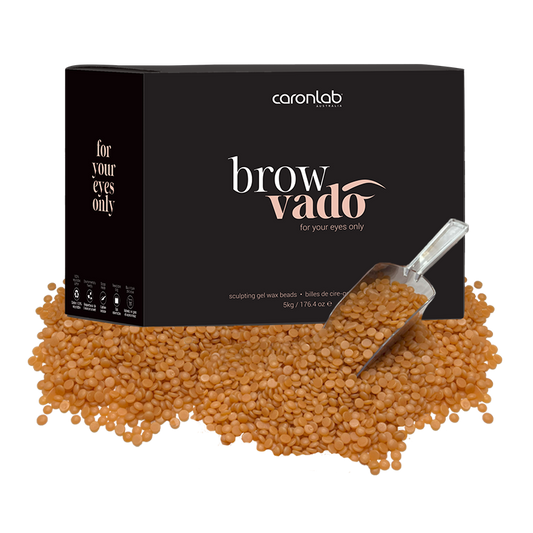 Caronlab brow vado packaging with brown wax beads and a scoop on a white background