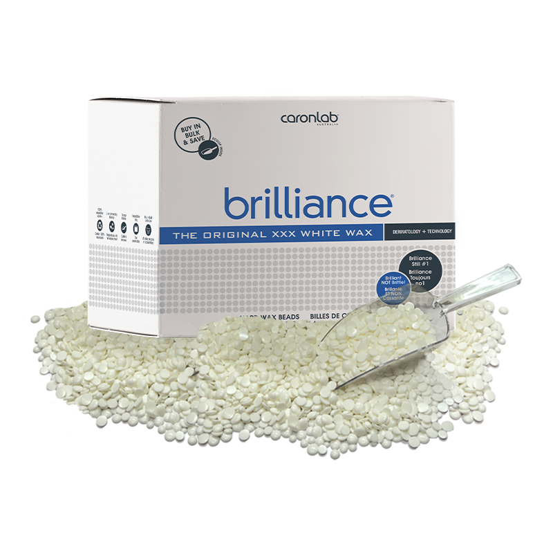 Box of Caronlab Brilliance white wax 5kg with a scoop and wax beads on a white background