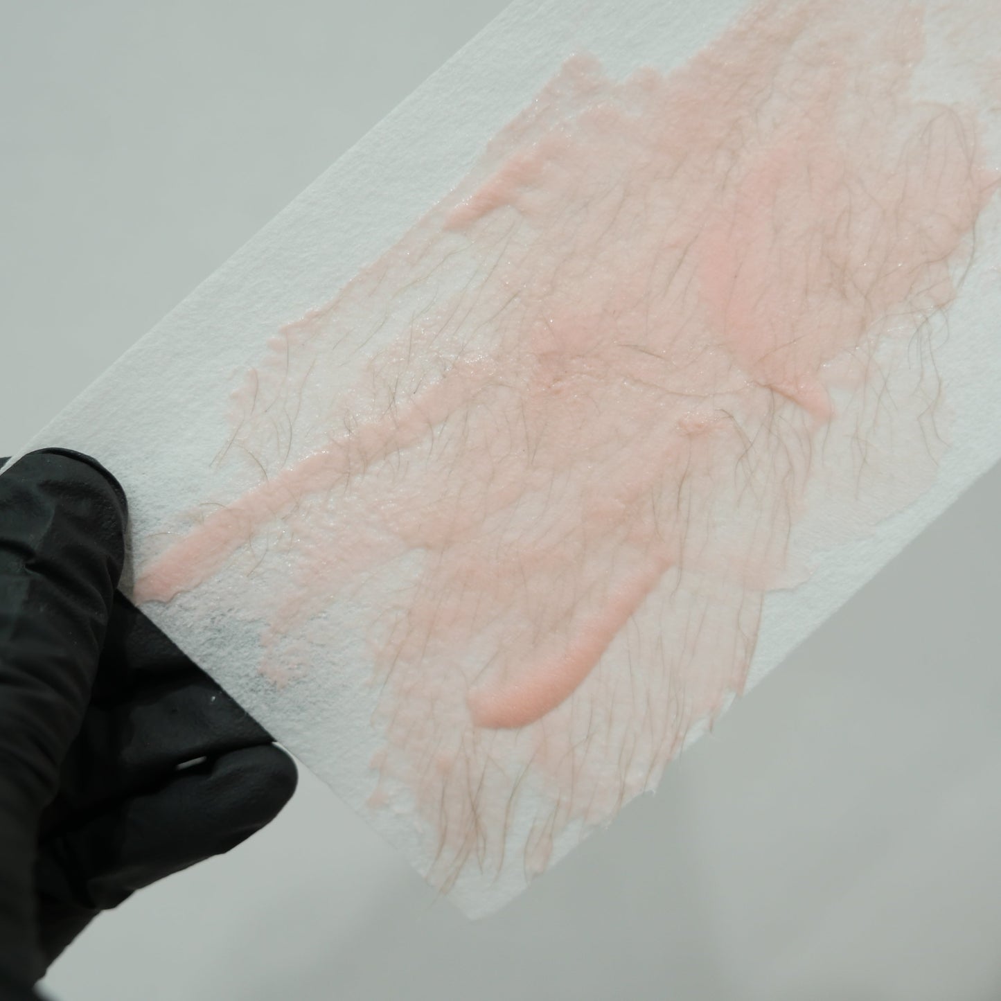 Professional waxing strip showing effective hair removal using Caronlab Deluxe Strawberry Creme Strip Wax
