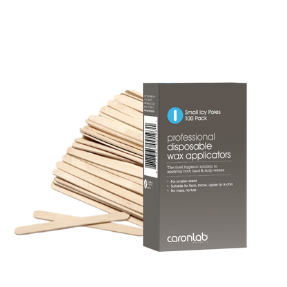 Box of professional disposable wax applicators with wooden waxing spatulas on a white background