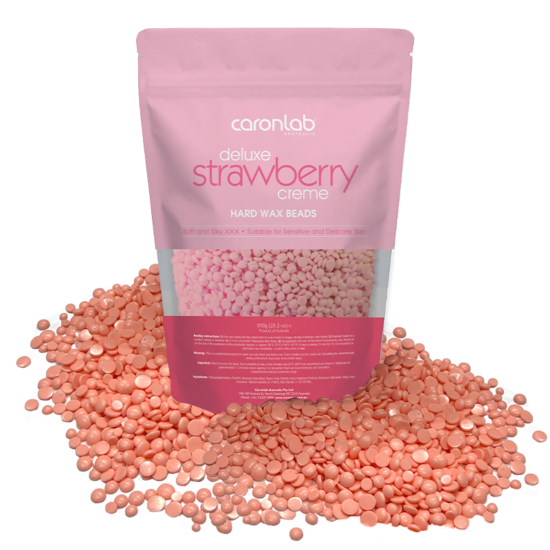 Pink packaging of Caronlab strawberry creme hard wax beads with wax beads spilling out on a white background.