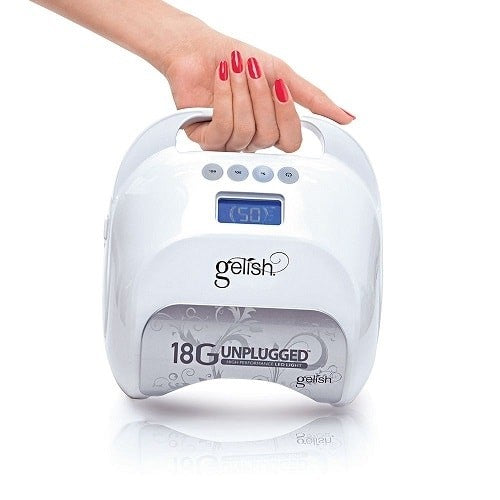 White gelish nail dryer with a hand holding it on a white background