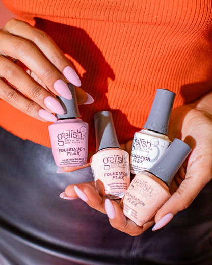 Gelish Foundation Flex rubber base coat colours held by a person with pink nails against an orange background