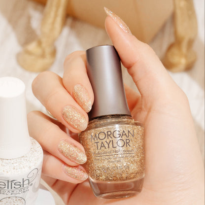 hand with Morgan Taylor All That Glitter Is Gold on the nails